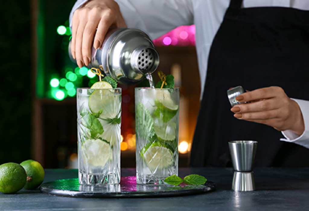 Bartender pouring mojitos at bar