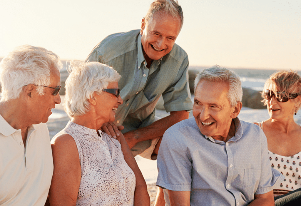 Group of seniors sitting outside talking and laughing