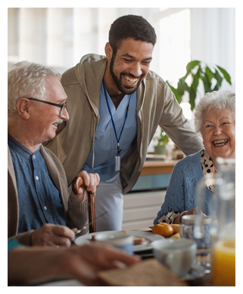 Plymouth Harbor on Sarasota Bay: Caregiver Laughing with Senior Couple Seated at Table