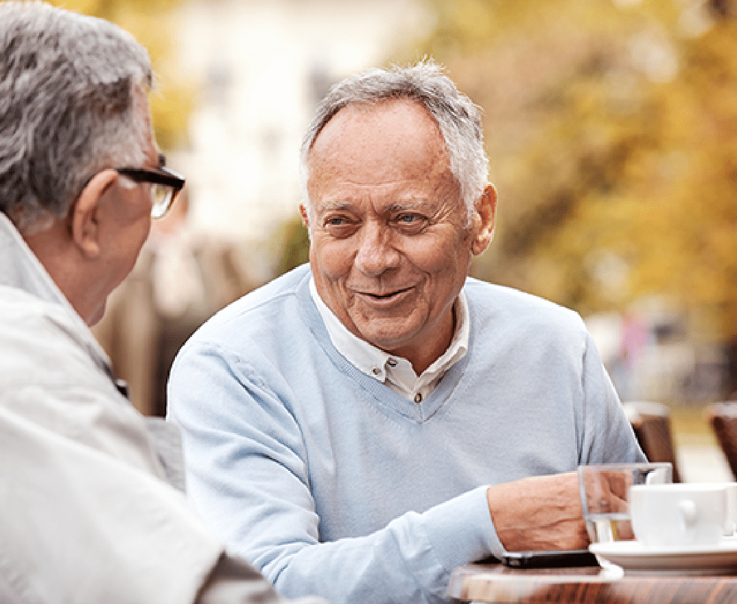 Plymouth Harbor on Sarasota Bay: Senior Men Sitting at Table Outside Talking