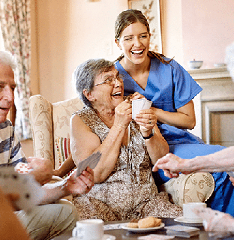 Plymouth Harbor on Sarasota Bay: Caregiver Sitting with Group of Seniors While They Play Cards