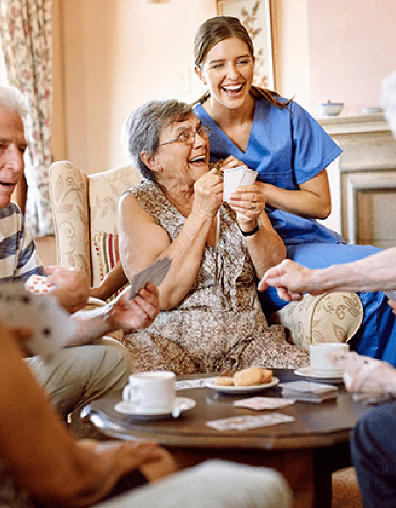 Plymouth Harbor on Sarasota Bay: Caregiver Sitting with Group of Seniors While They Play Cards