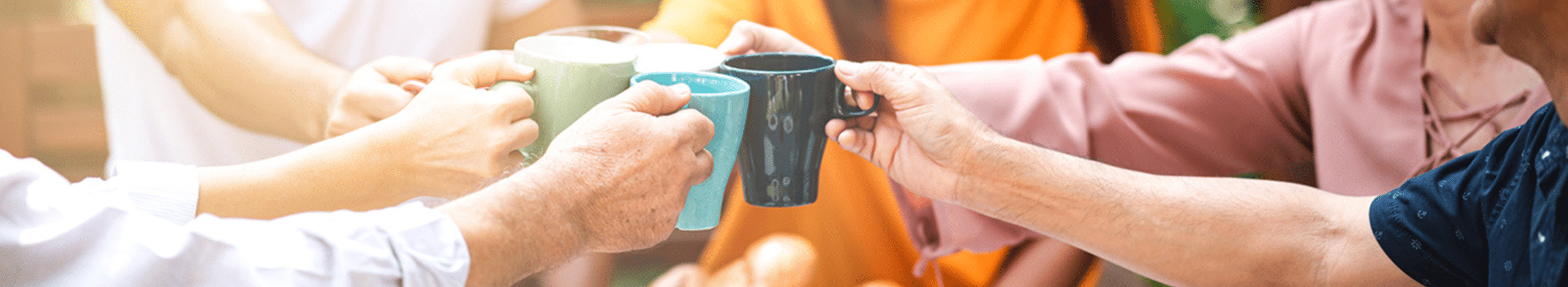 Seniors clinking coffee mugs