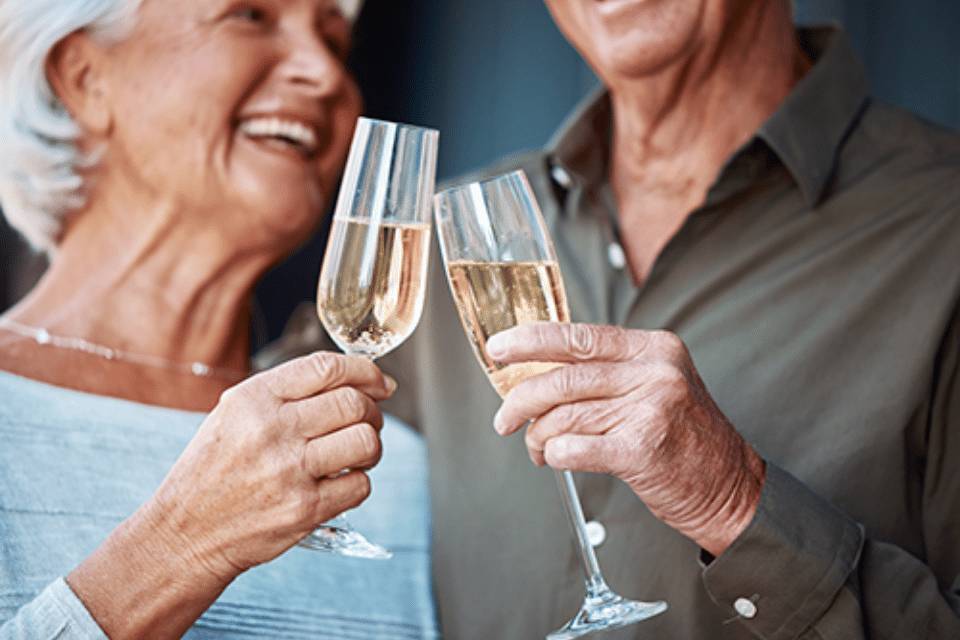 Happy senior couple clinking champagne flutes