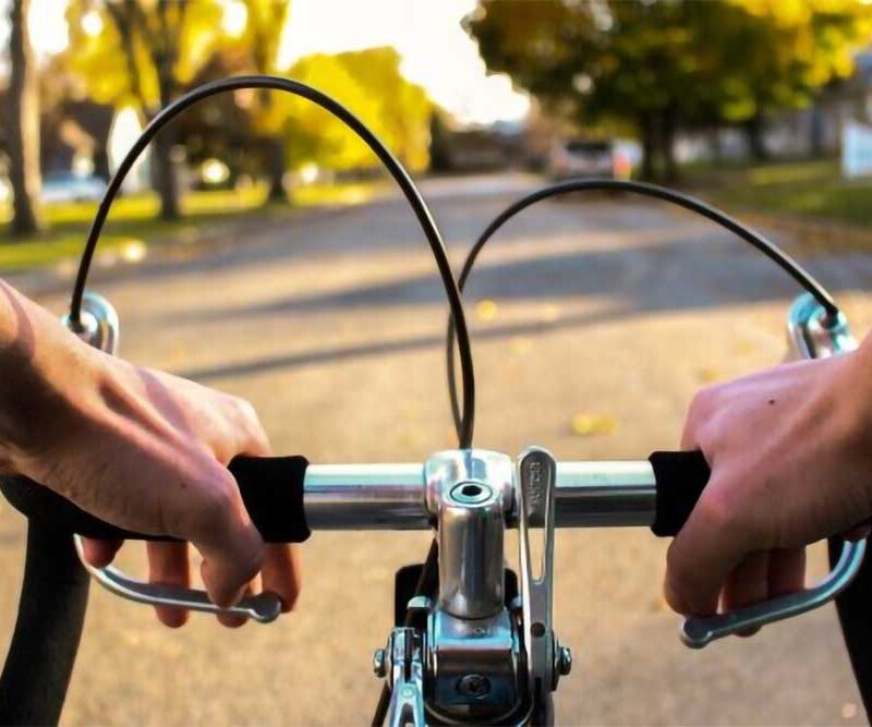 Close-up of a person's hands gripping the handlebars of a bicycle