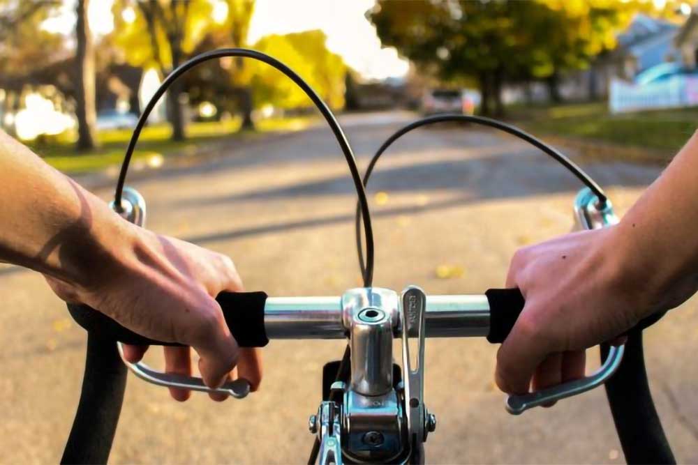 Close-up of a person's hands gripping the handlebars of a bicycle