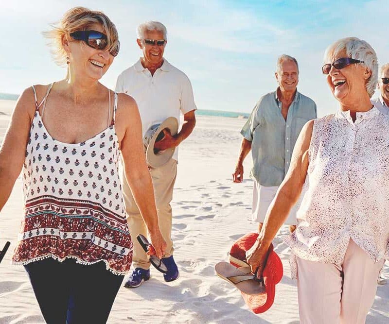 A group of senior women and men walking on the beach