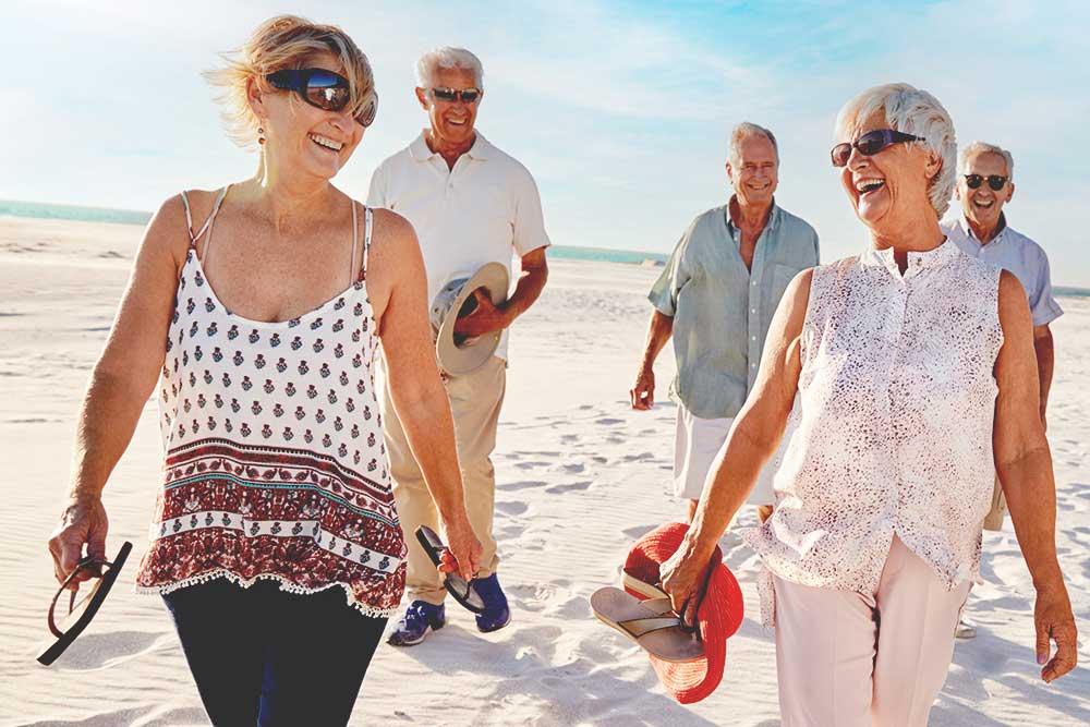 A group of senior women and men walking on the beach