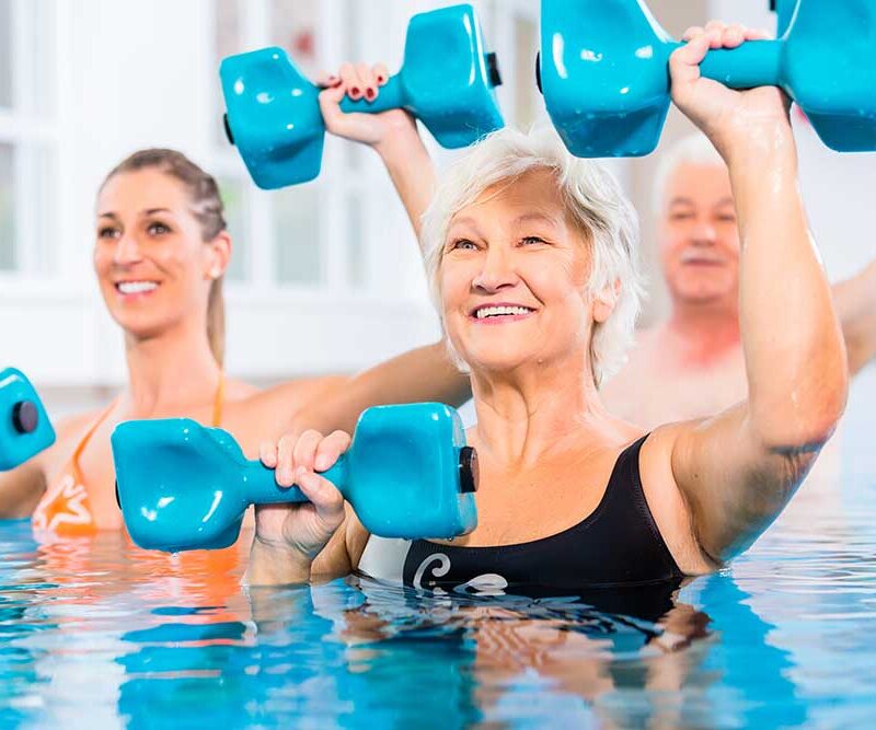 Senior women exercising in a pool with weights