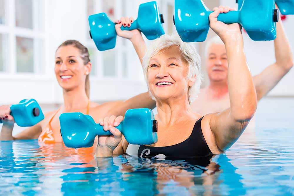 Senior women exercising in a pool with weights